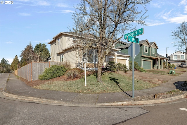 view of front facade with an attached garage and fence