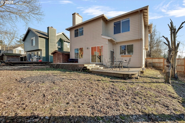 back of house featuring central AC unit, a chimney, fence, and a wooden deck