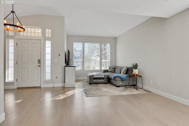 entryway featuring baseboards, wood finished floors, and a notable chandelier