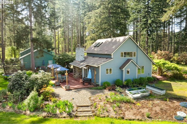 28272 S Hult Rd, Beavercreek, OR 97004 - rear view of property featuring a trampoline, a wooden deck, a chimney, and roof with shingles