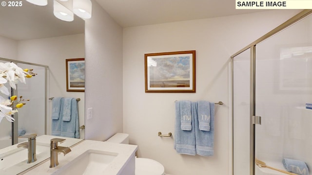 bathroom with vanity, toilet, and a shower with shower door