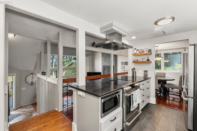 kitchen featuring open shelves, appliances with stainless steel finishes, island exhaust hood, white cabinetry, and a peninsula