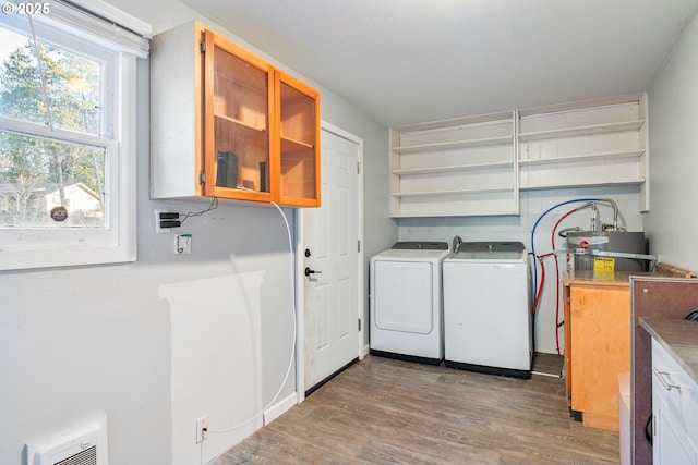 1502 Columbia St, Cathlamet, WA 98612 - laundry room with separate washer and dryer, strapped water heater, cabinet space, and wood finished floors