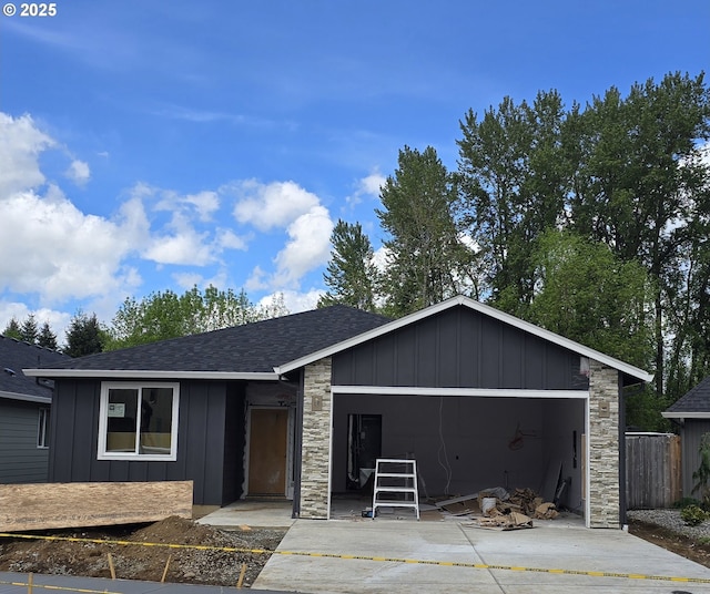 ranch-style home featuring board and batten siding, fence, a shingled roof, and stone siding