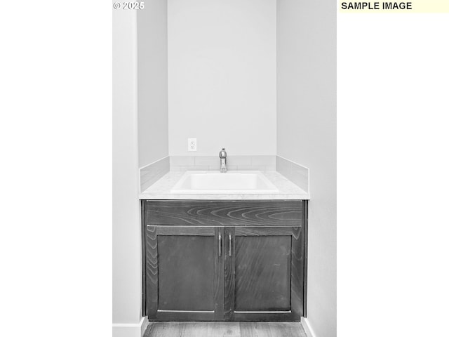 bathroom with vanity, baseboards, and wood finished floors