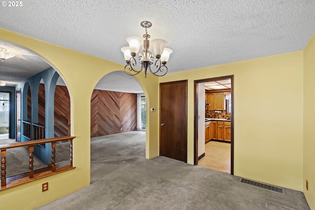 233 SE Paloma Ave, Gresham, OR 97080 - unfurnished dining area with light carpet, a chandelier, arched walkways, and a textured ceiling