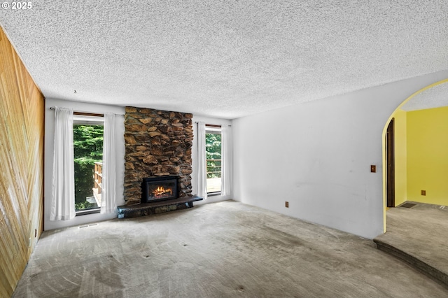 233 SE Paloma Ave, Gresham, OR 97080 - unfurnished living room with arched walkways, carpet floors, a textured ceiling, and a stone fireplace