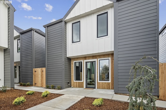 view of front of house with fence and board and batten siding