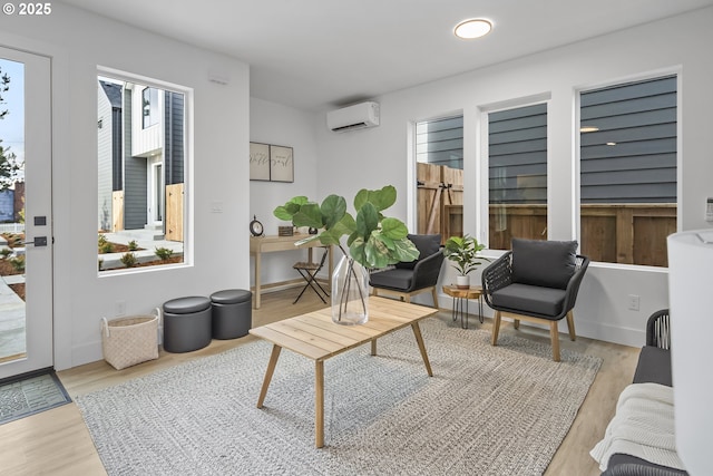 interior space featuring an AC wall unit, wood finished floors, and a wealth of natural light