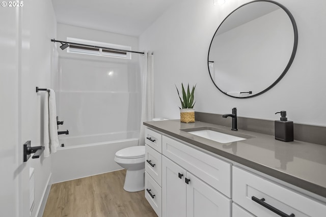 bathroom with toilet, shower / tub combo with curtain, wood finished floors, and vanity