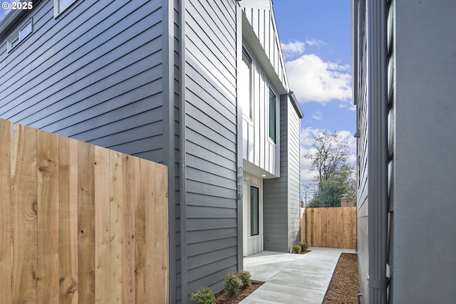 view of side of property with fence and a patio