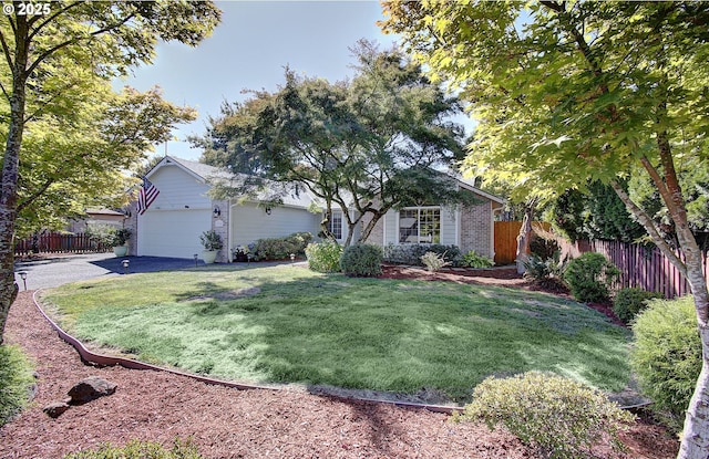 ranch-style house featuring brick siding, a front lawn, an attached garage, and fence