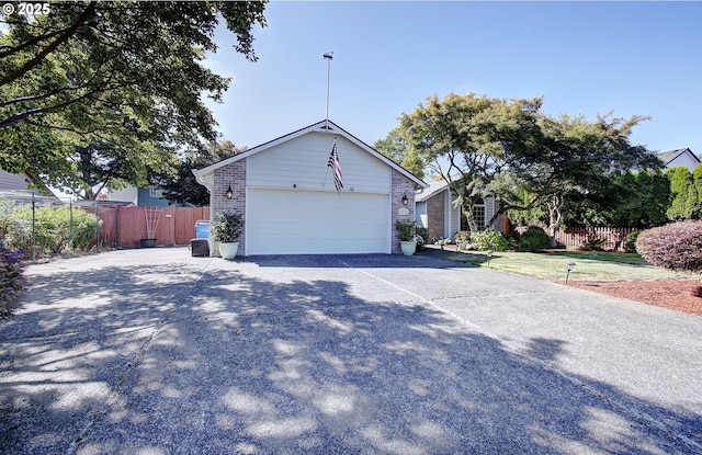 exterior space featuring concrete driveway, brick siding, and fence