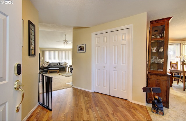 foyer with ceiling fan, baseboards, and wood finished floors