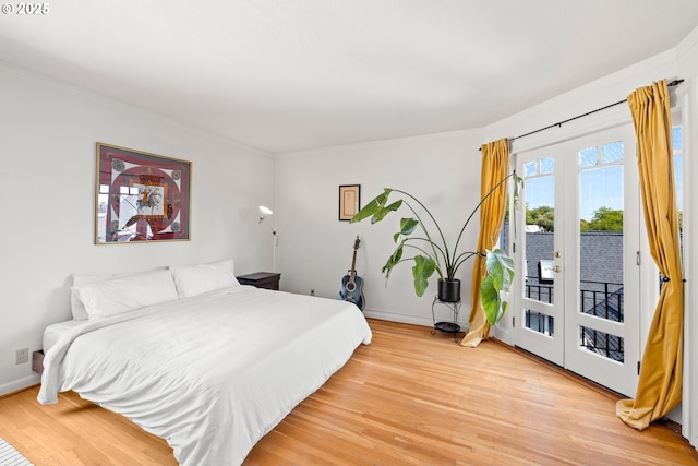 bedroom with access to exterior, french doors, and light hardwood / wood-style floors