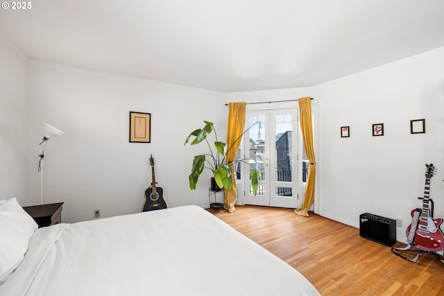 bedroom with access to exterior, hardwood / wood-style floors, and french doors