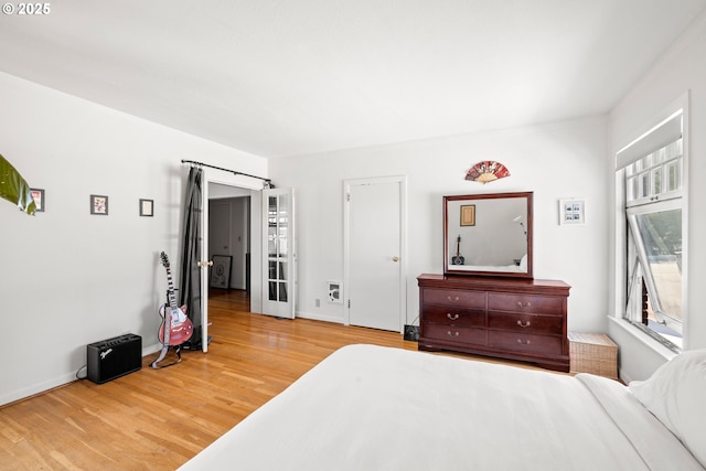 bedroom with multiple windows and hardwood / wood-style flooring