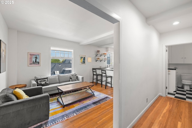 living room with beam ceiling and wood-type flooring