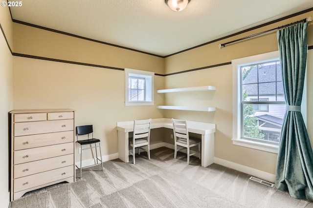 home office with visible vents, light colored carpet, crown molding, and baseboards