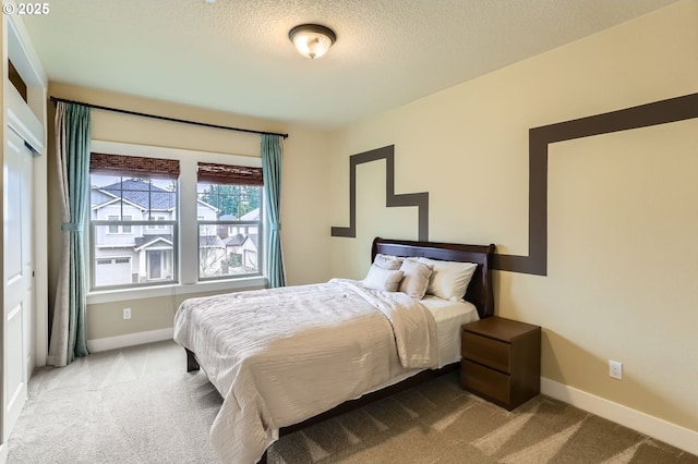 carpeted bedroom with baseboards and a textured ceiling