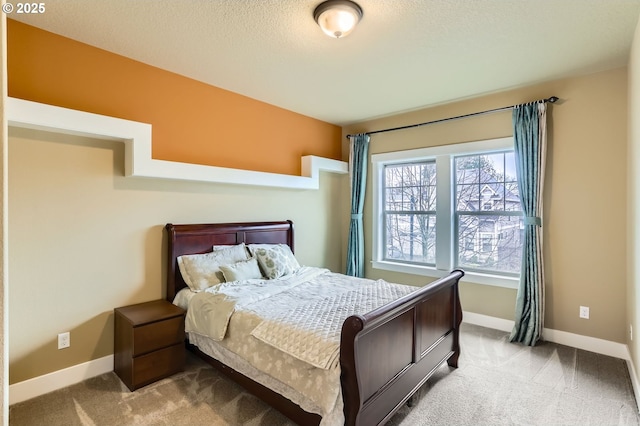 bedroom featuring baseboards, carpet floors, and a textured ceiling