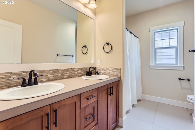 bathroom with decorative backsplash, double vanity, tile patterned floors, and a sink