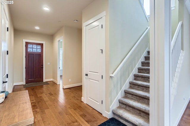 foyer with recessed lighting, baseboards, stairs, and light wood finished floors