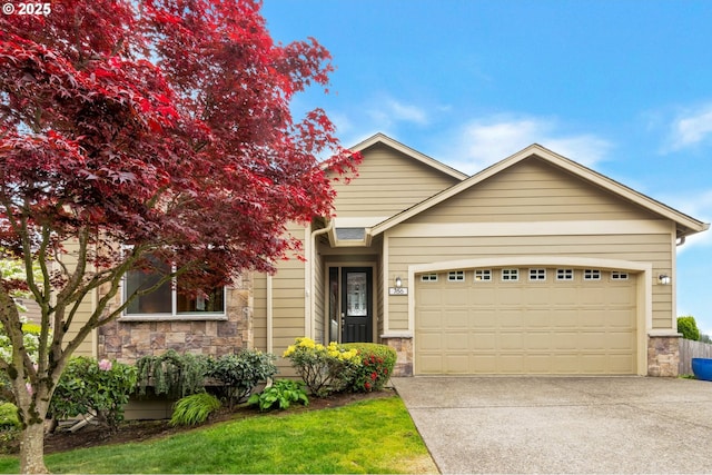 view of front of home featuring driveway, stone siding, and a garage