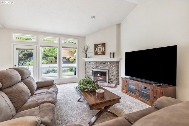 carpeted living room featuring a brick fireplace and vaulted ceiling
