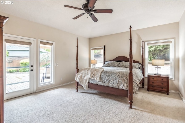 carpeted bedroom featuring baseboards, multiple windows, and access to exterior