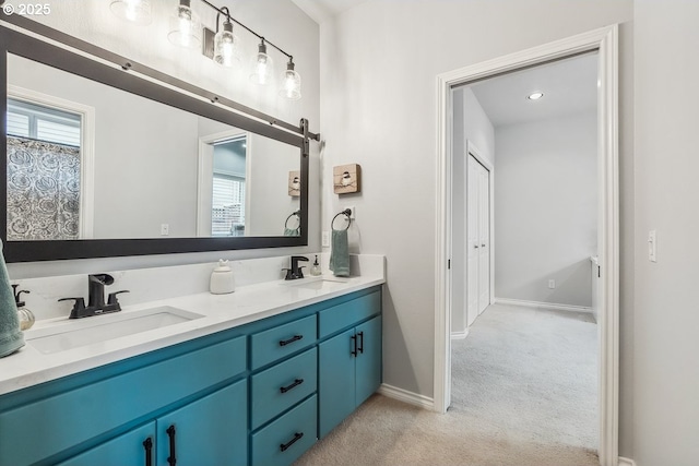 bathroom featuring a sink, baseboards, and double vanity