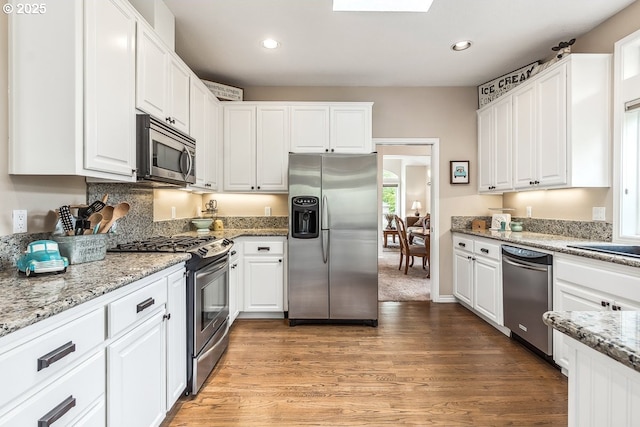 kitchen with white cabinets, stainless steel appliances, recessed lighting, and light wood-type flooring