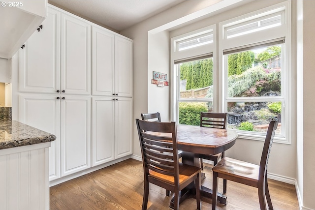dining area featuring baseboards and light wood finished floors