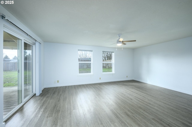 spare room featuring a ceiling fan, baseboards, and wood finished floors