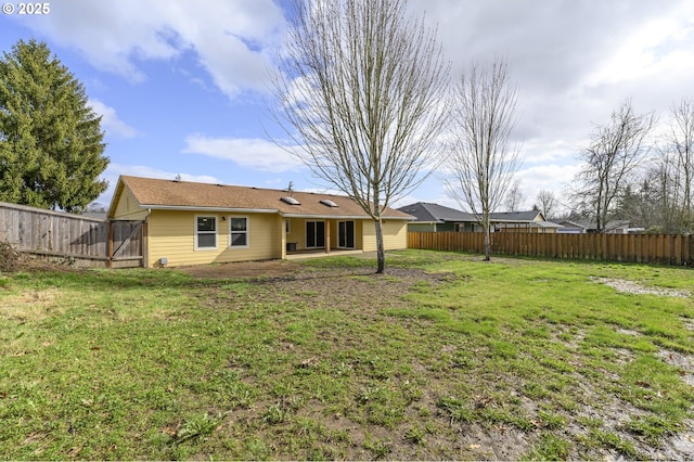 rear view of property featuring a lawn, a patio area, and fence private yard