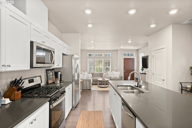 11469 SW Mont Blanc St, Wilsonville, OR 97070 - kitchen featuring stainless steel appliances, open floor plan, light wood finished floors, white cabinetry, and recessed lighting