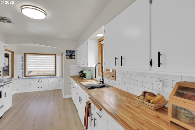 8011 SE Lambert St, Portland, OR 97206 - kitchen with backsplash, a sink, white cabinets, wood counters, and light wood-style flooring