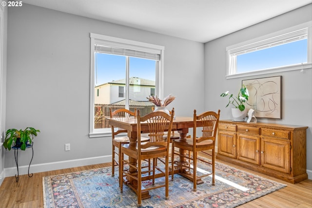 dining area with baseboards and light wood-type flooring