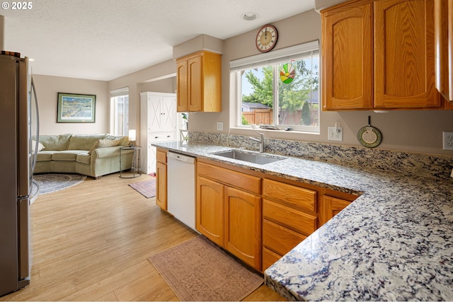 1190 Hazelnut Ct, Creswell, OR 97426 - kitchen featuring white dishwasher, a sink, freestanding refrigerator, open floor plan, and light wood-style floors