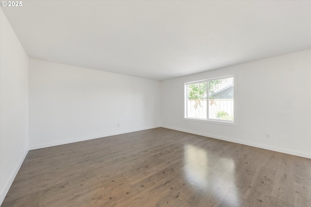 empty room with wood finished floors and baseboards