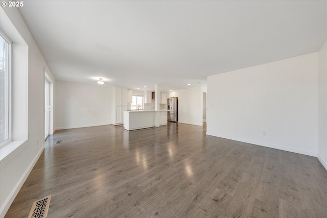 unfurnished living room featuring wood finished floors and recessed lighting
