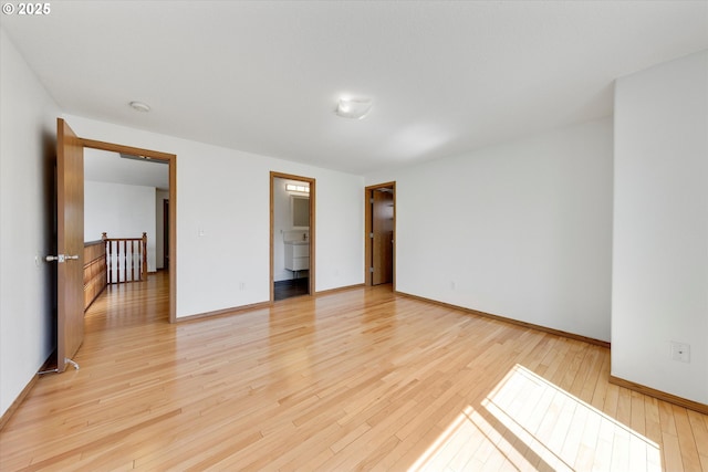 spare room featuring light wood finished floors and baseboards