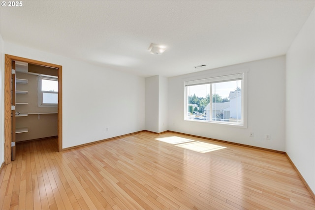 unfurnished room with baseboards and light wood finished floors