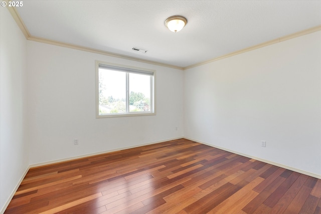 spare room with hardwood / wood-style flooring and crown molding