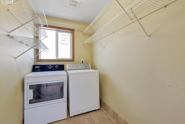 washroom with separate washer and dryer and light tile patterned floors