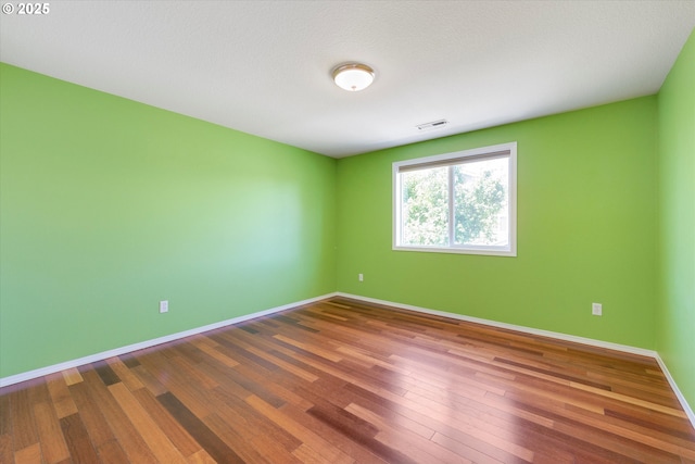 unfurnished room with wood finished floors and baseboards