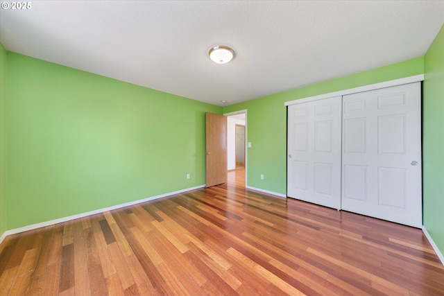unfurnished bedroom featuring wood finished floors and a closet