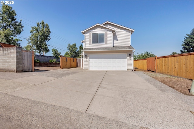 traditional home featuring driveway, a garage, and a gate