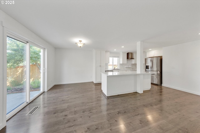 kitchen with stainless steel fridge, stove, a center island, healthy amount of natural light, and recessed lighting