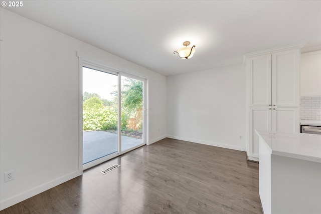 unfurnished dining area with wood finished floors and baseboards